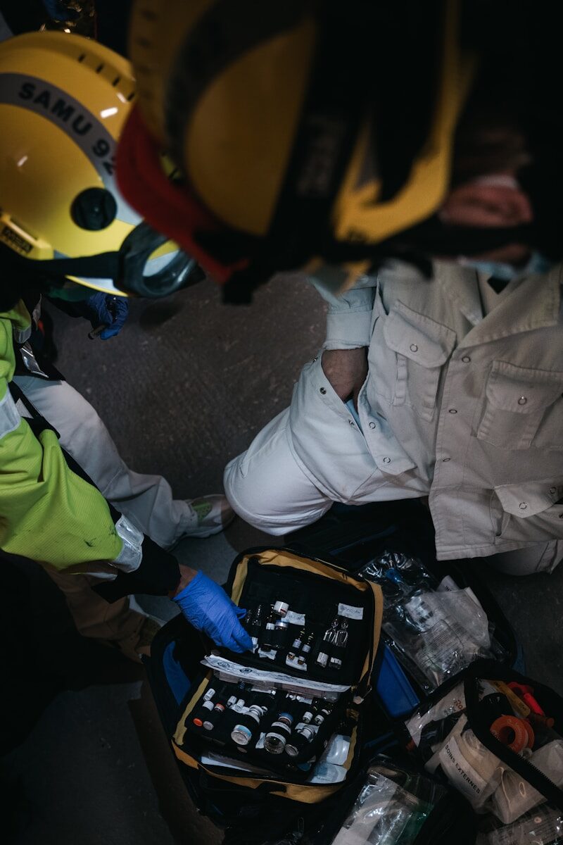 a man sitting on the ground next to a helmet